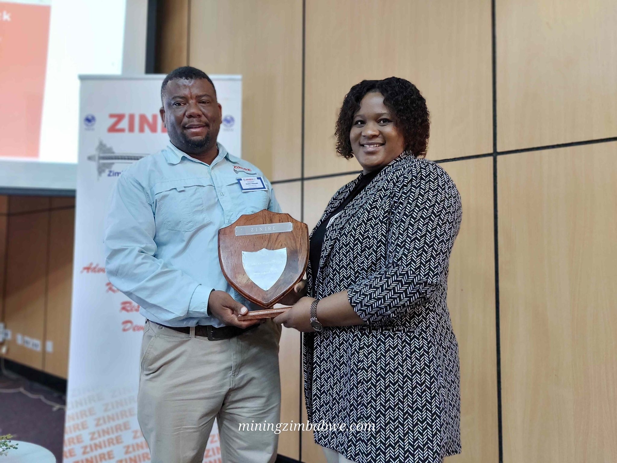 Fungai-Kwangwari-at-the-ZINIRE-symposium-2024-002-2048x1536 SRK Consulting mining geotechnical engineer Fungai Kwangwari (right) recently earned the Best Technical Presentation award at the Zimbabwe National Institute of Rock Engineering symposium in Bulawayo.